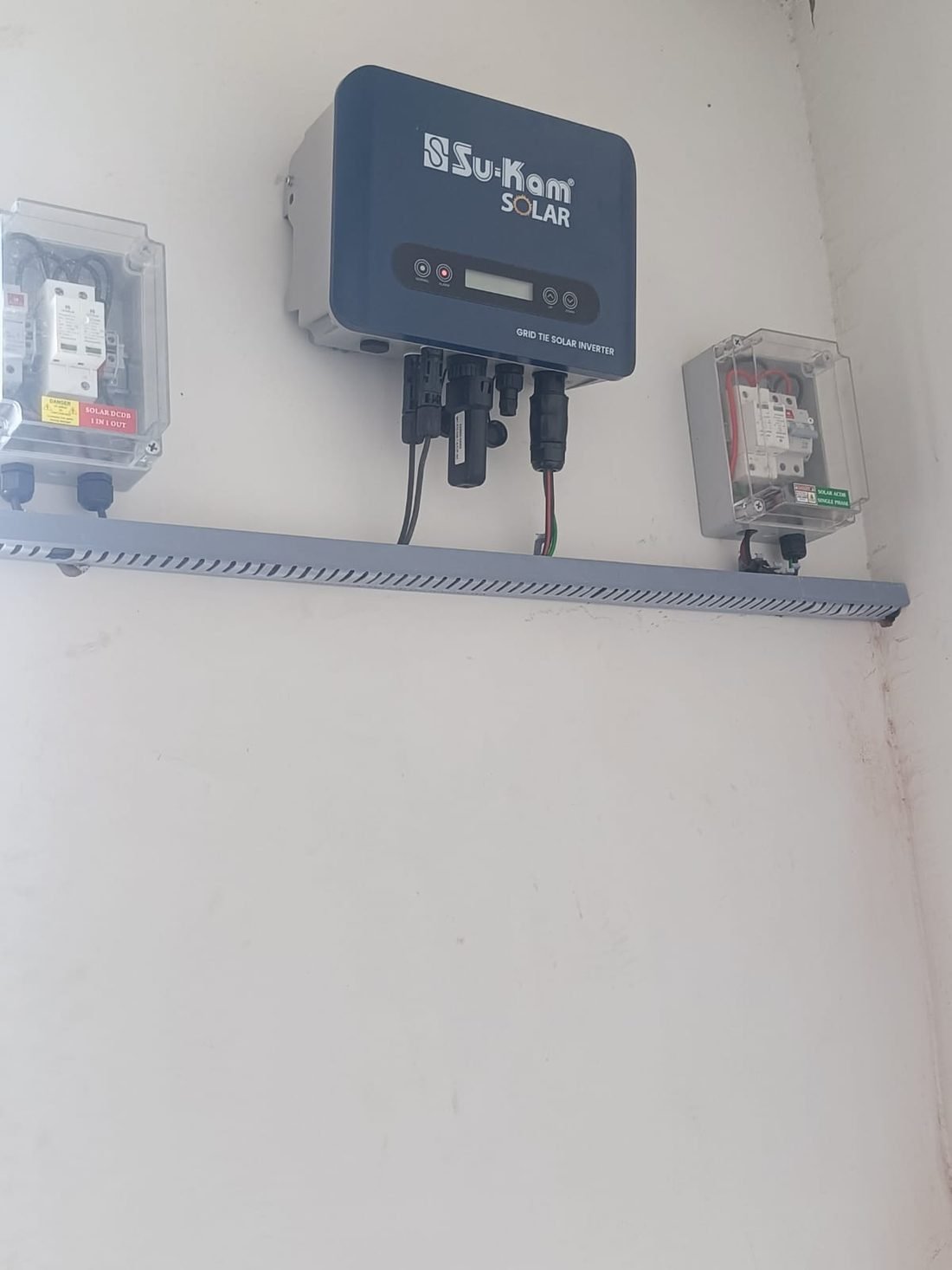 Su-Kam grid-tie inverter with protection boxes installed on a wall